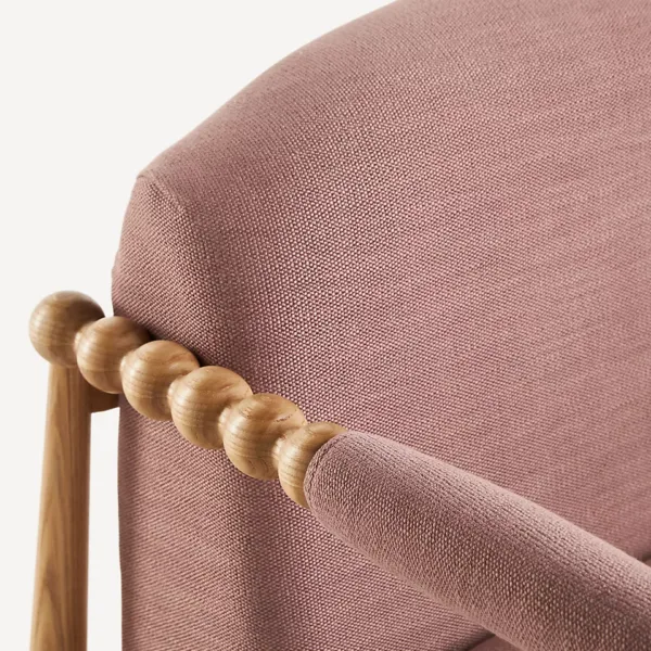 Close up of dusty rose fabric and ash wood beaded arm on INTERIORZE Pink Ash Wood Armchair
