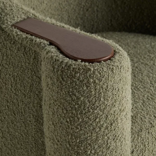 Close-up of boucle fabric and wooden arm-top insert on olive green lounge chair