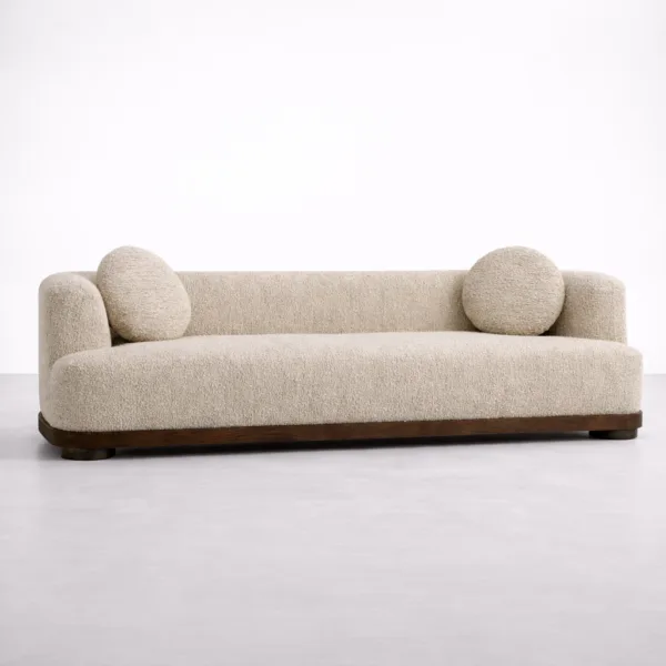 Wide front view of teakwood boucle sofa in ivory with rounded arms and low profile