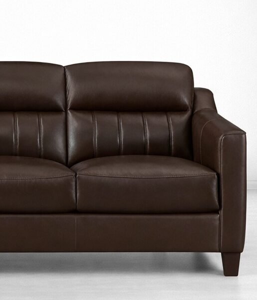 Close-up of dark brown faux leather 3 seater sofa showing stitching and arm detail
