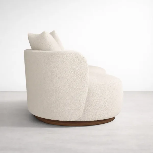 Side view of ivory boucle sofa showing curved silhouette and teakwood base