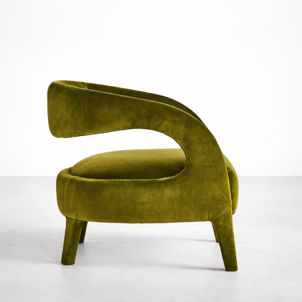 Side view of olive green velvet lounge chair with sculpted open back