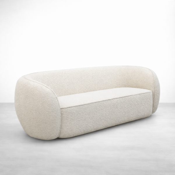 Angled view of cream boucle curved sofa showing curved backrest by INTERIORZE