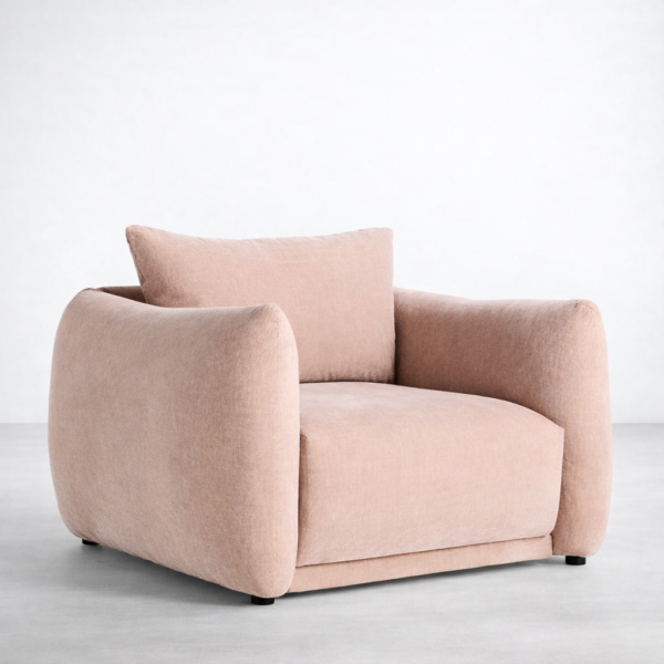 Angled view of blush pink lounge chair with deep seat and wide arms