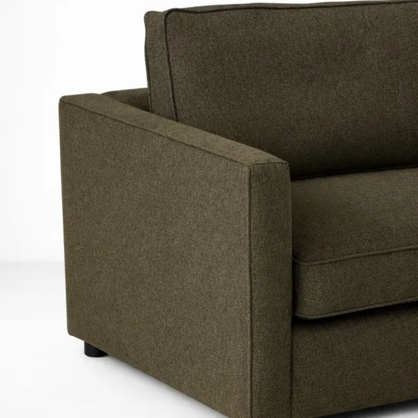 Close-up of olive green fabric upholstery and straight arm on INTERIORZE sofa