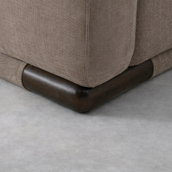 Close-up of teakwood base with walnut polish on beige linen sofa by Interiorze