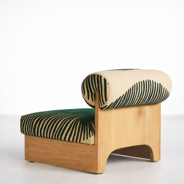 Angled rear view of lounge chair with teakwood back panel and patterned roll cushion