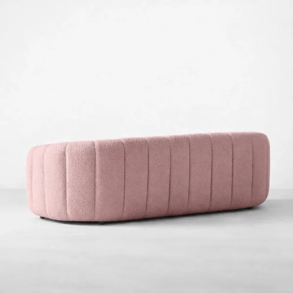 Back angled view of INTERIORZE Aisha pink boucle 3 seater sofa with fully upholstered channel back