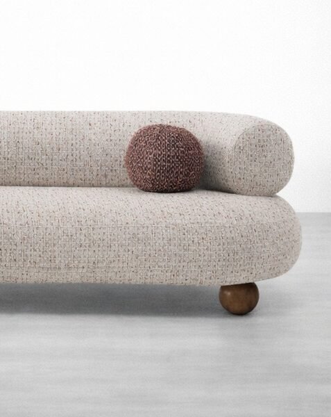 Wooden ball feet detail on curved boucle 3 seater sofa by INTERIORZE