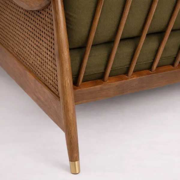 Teakwood cane sofa leg close-up with brass cap and warm wood polish
