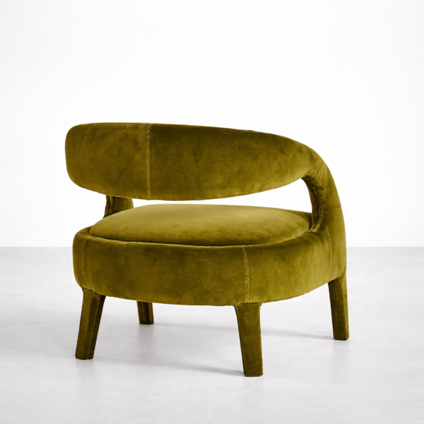 Angled rear view of olive green velvet lounge chair with curved back