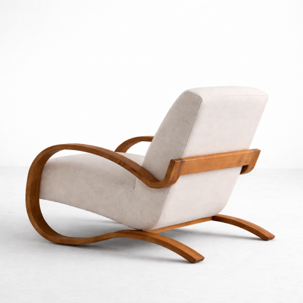 beige lounge chair with sculpted teakwood arms