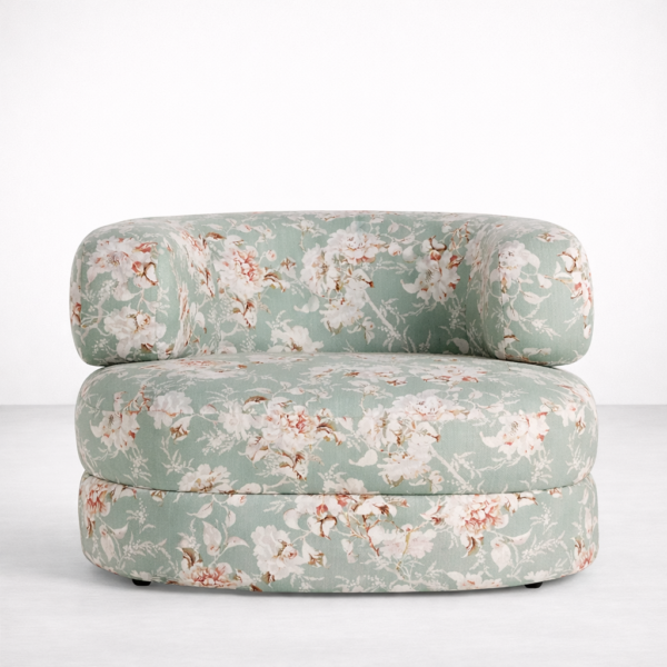 Angled view of round floral accent chair in sage green upholstery