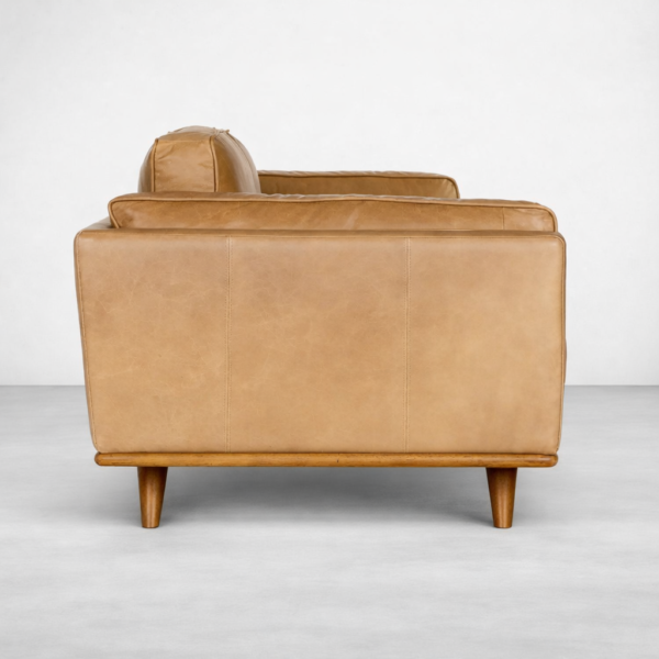 Side view of tan leather 3 seater sofa showing wooden base and legs