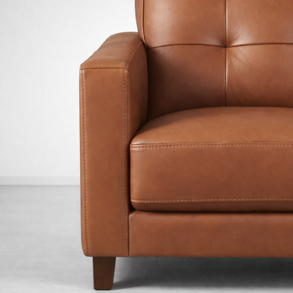Close-up of brown faux leather 3 seater sofa arm and stitching by INTERIORZE