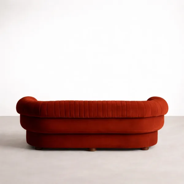 Back view of red velvet sofa with channel tufting and rounded silhouette
