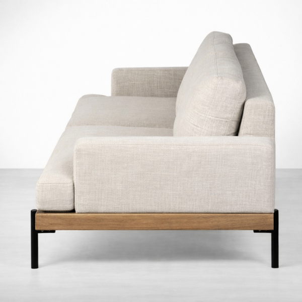 Side view of teakwood base linen sofa with metal legs by Interiorze