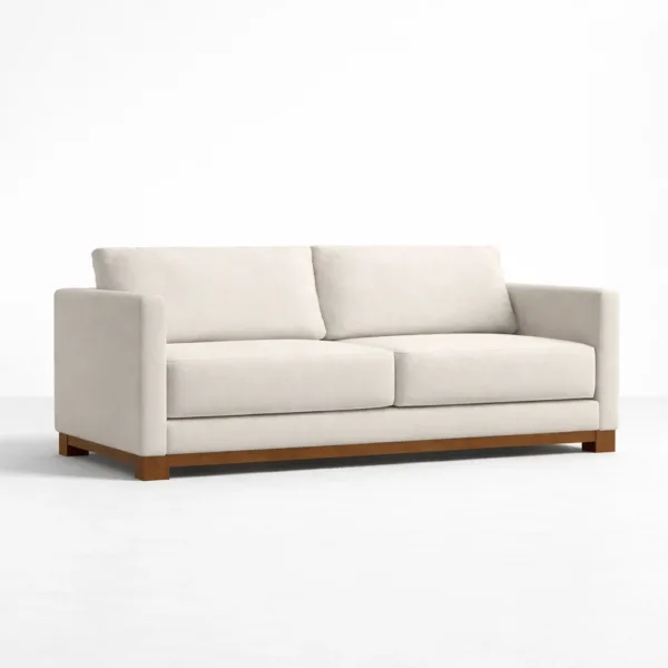 Angled view of ivory fabric sofa with teakwood frame and base by INTERIORZE