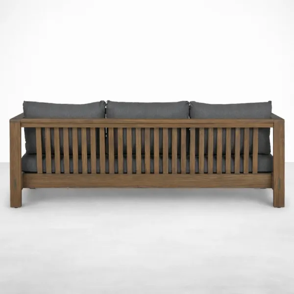 Back view of teakwood outdoor sofa with slatted back design and charcoal cushions by INTERIORZE
