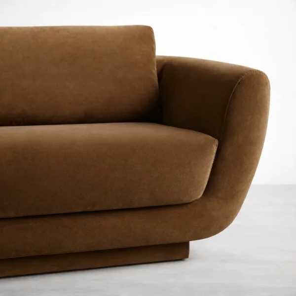 Close-up of teakwood brown sofa showing curved arm and smooth upholstery texture