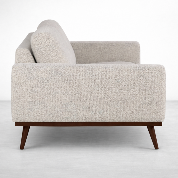 Side view of beige fabric sofa on teakwood base by INTERIORZE