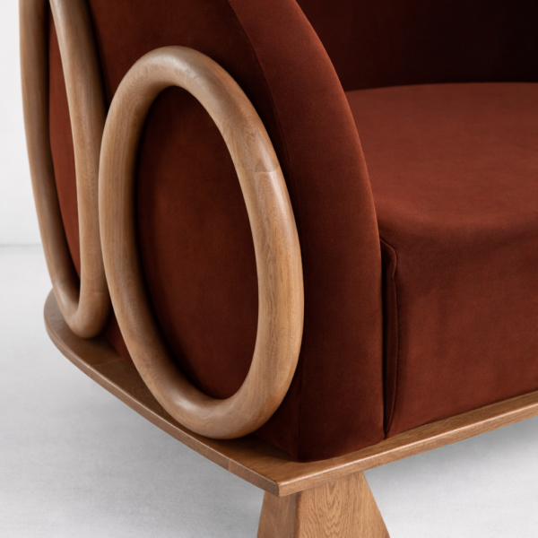 Close-up of rust velvet seat and circular ash wood ring on lounge chair