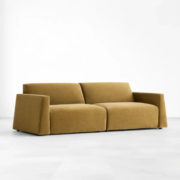 Angled view of mustard velvet sofa with clean arms by INTERIORZE
