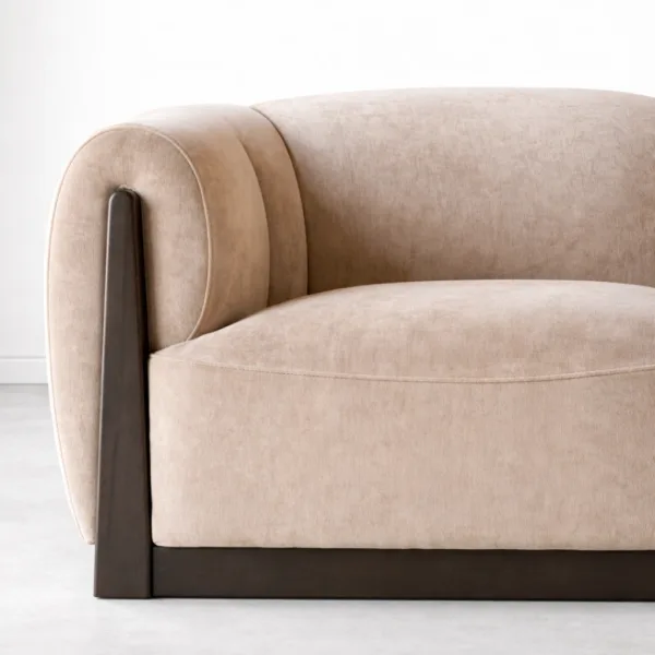 Beige velvet sofa arm close up with dark teakwood side support INTERIORZE Teakcrest