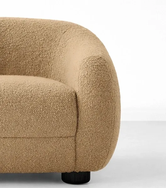 Beige boucle lounge chair close-up showing boucle texture and teakwood leg detail, INTERIORZE SANDDUNE.