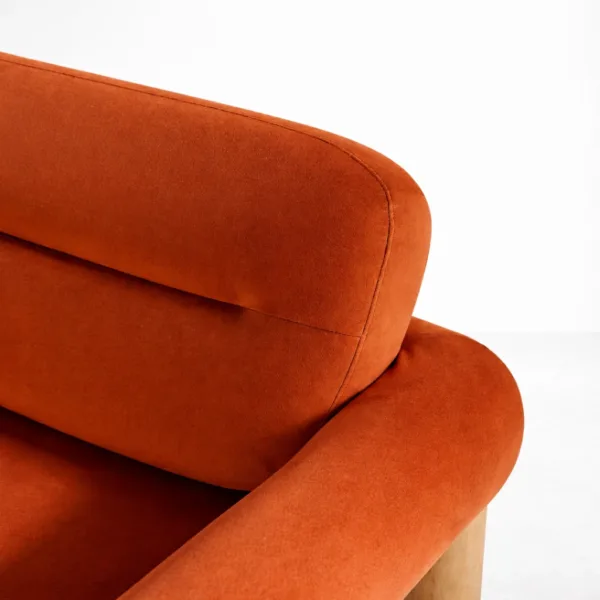 Rust orange sofa back and arm close-up showing velvet-touch upholstery finish