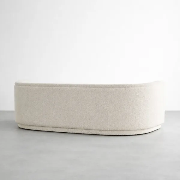 Back view of INTERIORZE Arcline ivory boucle 2 seater sofa with smooth curved profile and wrapped base