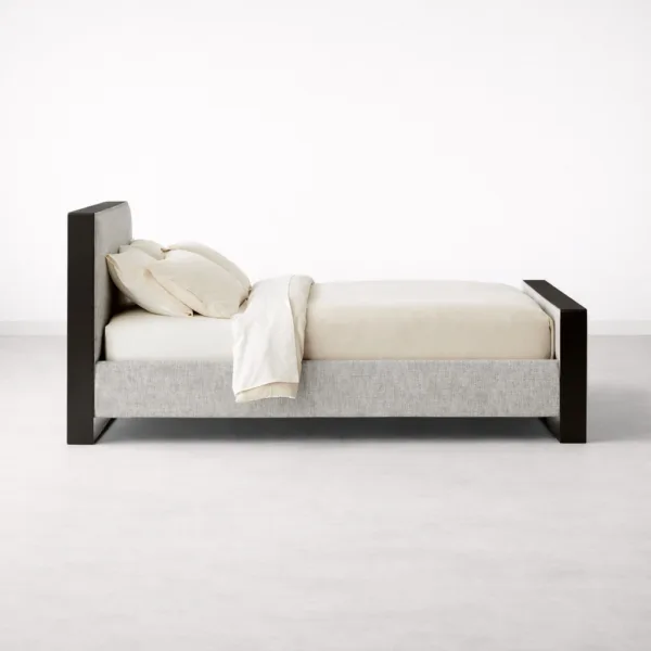 Side view of INTERIORZE Aster teakwood upholstered bed with metal legs and upholstered side panel