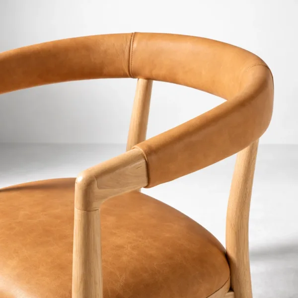 Close up teakwood upholstered dining chair padded back rail tan upholstery