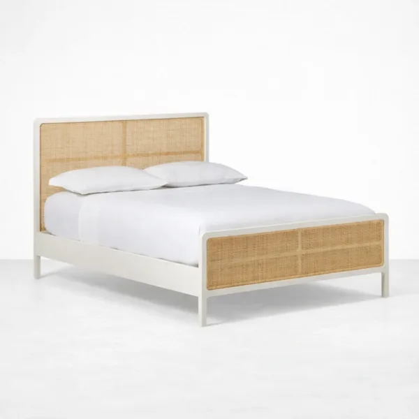 Cane panel bed angle view showing ivory frame and natural cane footboard panel