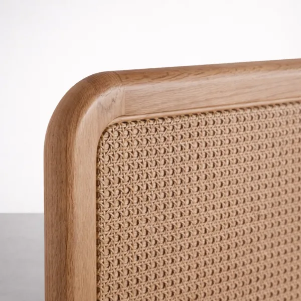 Close-up of teakwood cane bed headboard showing cane weave and smooth rounded corner
