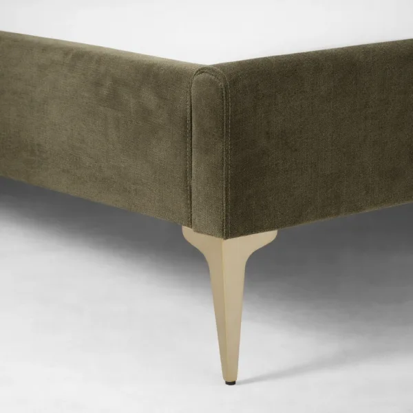 Gold leg detail of olive upholstered bed showing premium finish