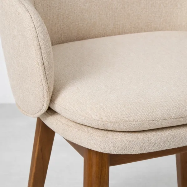 Ivory bouclé upholstery close-up on teak accent chair seat cushion