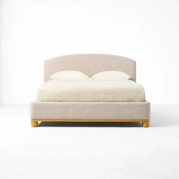Front view of an upholstered teakwood bed with arched headboard and beige upholstered frame