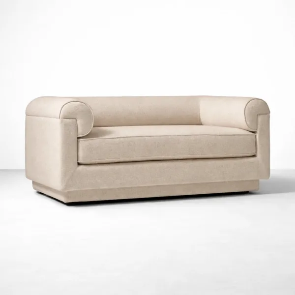 Angled view of beige 2 seater sofa with roll arms and upholstered base.