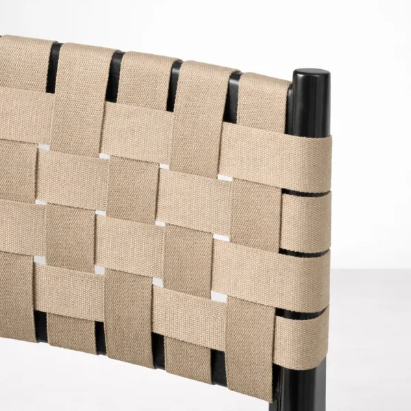 Close up of strap back dining chair beige woven webbing on black teakwood frame