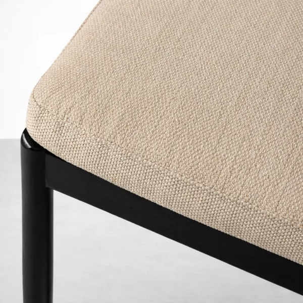 Beige fabric upholstery texture and black teakwood frame detail on INTERIORZE Mono dining chair