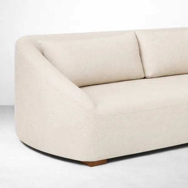 Curved ivory linen sectional sofa with teakwood plinth base detail