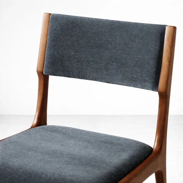 Close-up of blue upholstery on solid teak wood dining chair