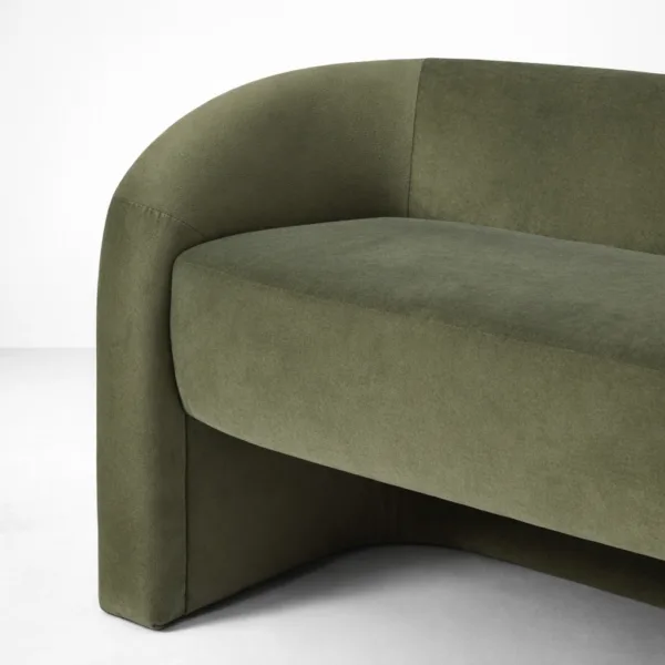 Close-up of INTERIORZE Olive Arc olive green velvet 2 seater sofa showing rounded armrest and smooth curved upholstery