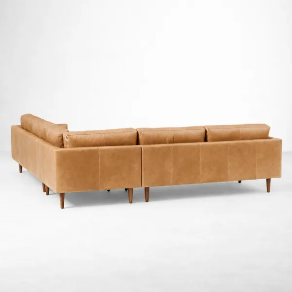 Back view of tan leather L shaped sectional sofa with tapered wooden legs by INTERIORZE