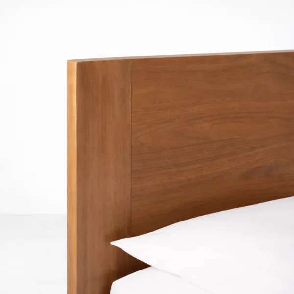 Teakwood headboard corner detail with warm polish on a solid teakwood bed