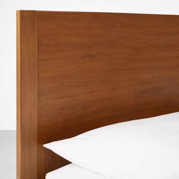 Close-up of teakwood grain on wide headboard with smooth curve