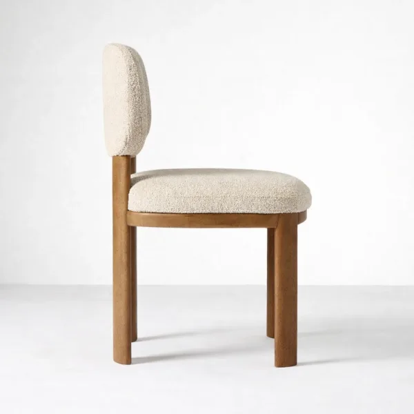 Side view of bouclé dining chair in ivory with teak wood frame