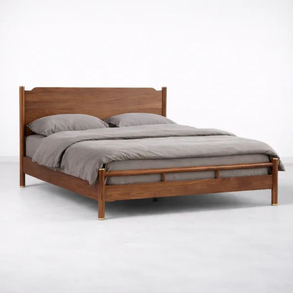 Angled view of solid teakwood bed frame with brass leg detailing by INTERIORZE