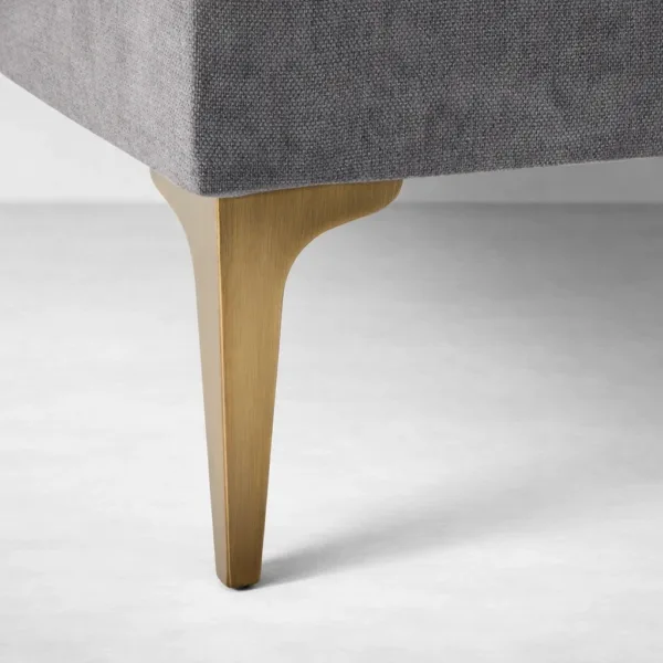 Brass-finish sofa leg detail on charcoal grey sectional by INTERIORZE